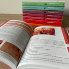 Open Acute Medicine book, with other books stacked in the background.
