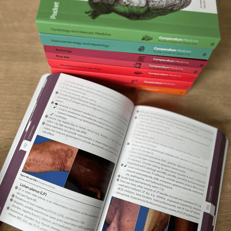 Open Dermatology book with images on different skin colours, with a stack of colourful books in the background.